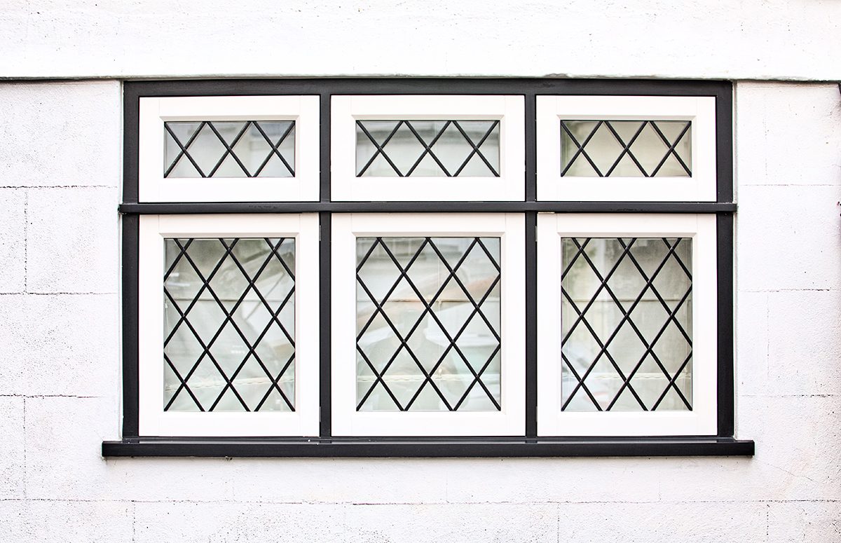 Three-light leaded casement window in a white wall